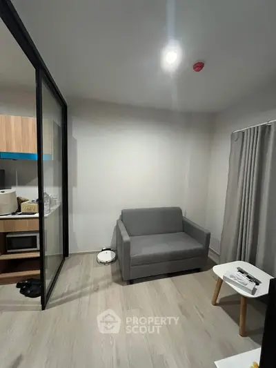 Modern compact living room with sofa and kitchenette in open layout apartment