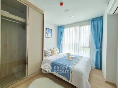 Bright and cozy bedroom with large window and blue curtains