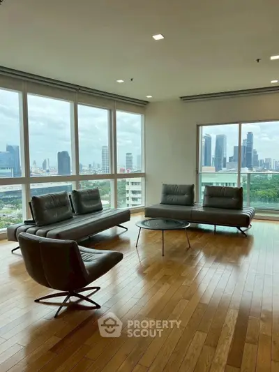 Spacious living room with panoramic city views and modern furniture.