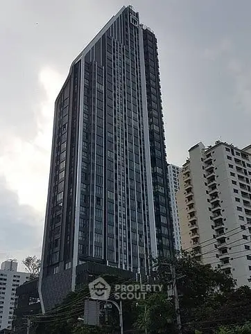 Modern high-rise building with sleek design and urban skyline view.