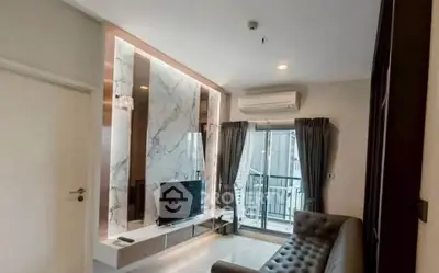 Modern living room with marble accent wall and balcony access in a stylish apartment.