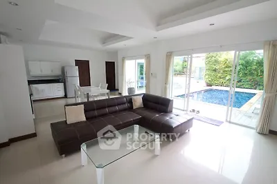 Spacious living room with pool view, modern furniture, and open layout in luxury home.