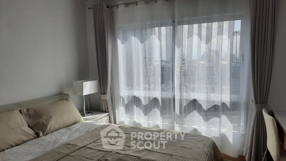 Bright and cozy bedroom with large window and elegant curtains in modern apartment.