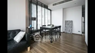 Modern living room with sleek furniture and large windows in urban apartment.