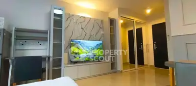 Modern living room with sleek TV setup and mirrored closet doors