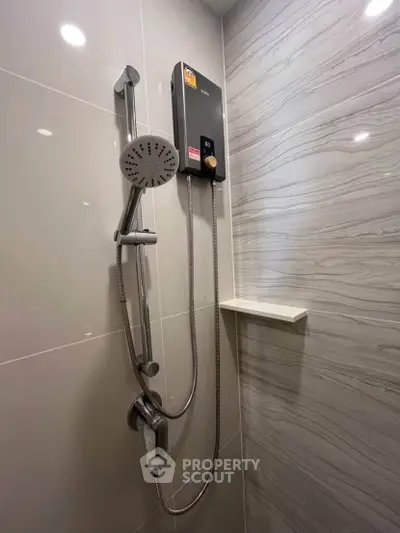 Modern bathroom shower with sleek design and water heater in a stylish tiled setting.