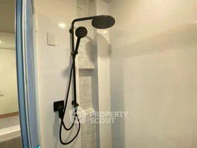 Modern bathroom with sleek black shower fixtures and elegant tile design.