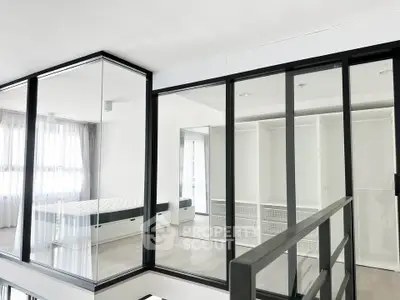 Modern bedroom with glass walls and minimalist design in a contemporary apartment.