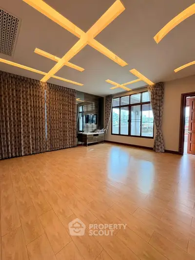 Spacious living room with modern lighting and large windows in a luxury apartment.