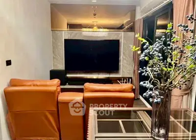 Stylish living room with leather seating and large TV, perfect for entertainment.