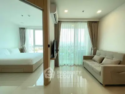 Modern apartment with spacious living room and bedroom, featuring large windows and natural light.