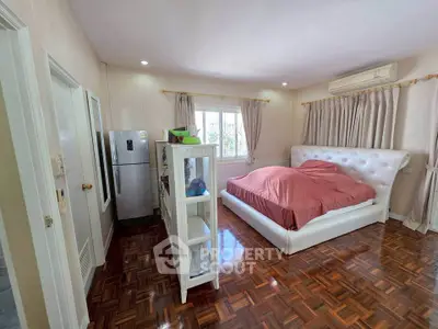 Spacious bedroom with elegant parquet flooring and modern furnishings