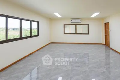 Spacious empty room with large windows and air conditioning, perfect for customization.