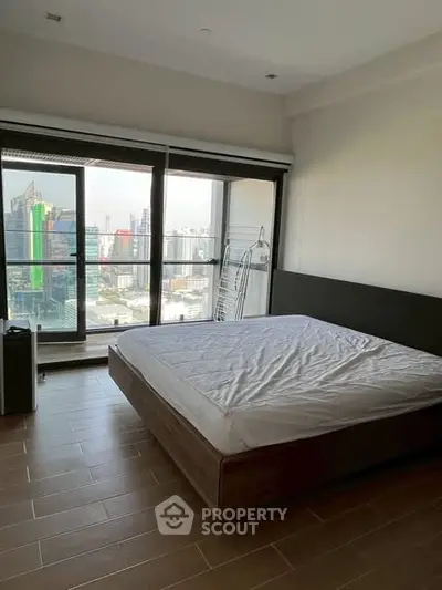 Spacious bedroom with city view and large windows in modern apartment