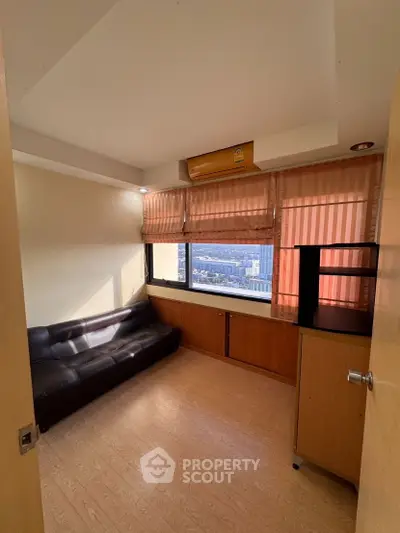 Cozy study room with city view, leather sofa, and ample natural light