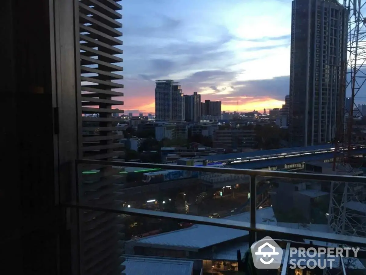 Stunning cityscape view from a high-rise balcony at sunset, showcasing urban skyline.