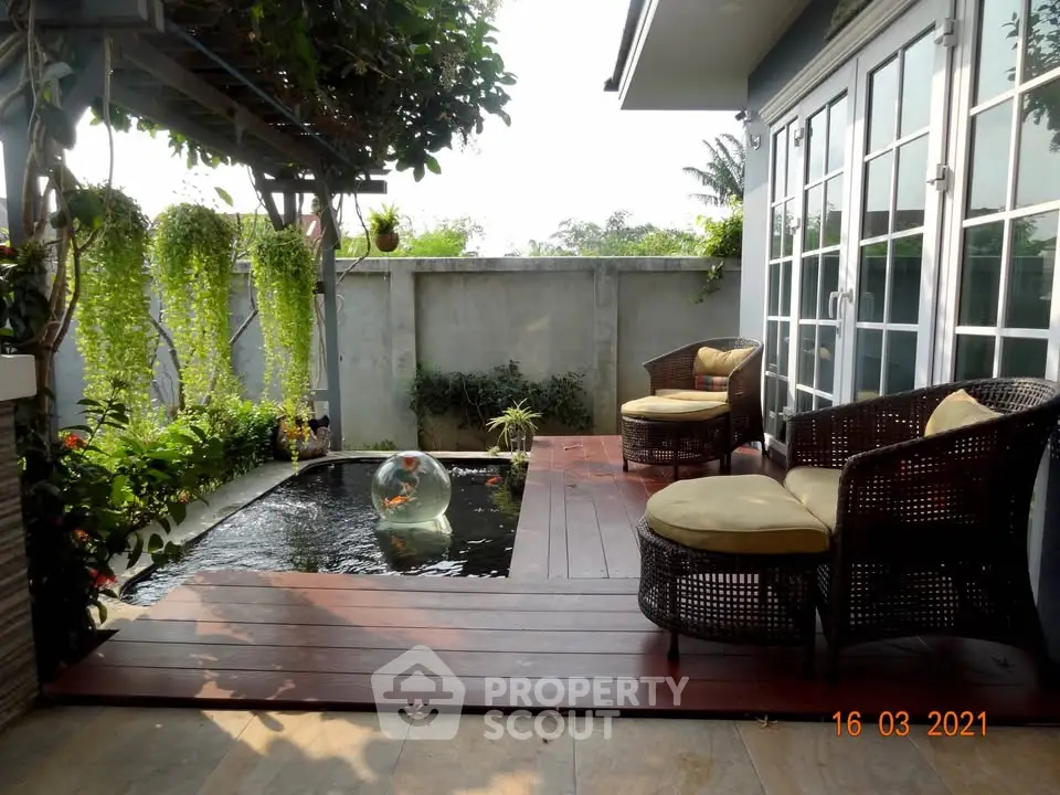 Charming outdoor patio with cozy seating and serene fish pond, perfect for relaxation and entertaining.