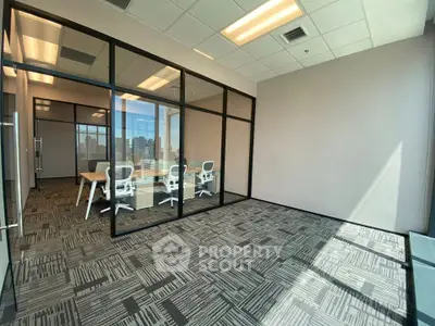 Modern office space with glass walls and city view, ideal for professional meetings.
