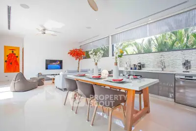 Modern open-plan living room and kitchen with sleek design and natural light.