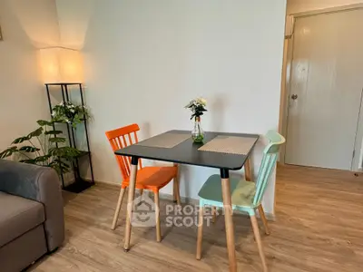 Charming dining area with colorful chairs and cozy lighting in a modern apartment.