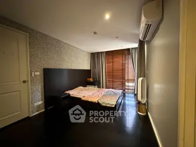 Spacious bedroom with modern decor and large window for natural light