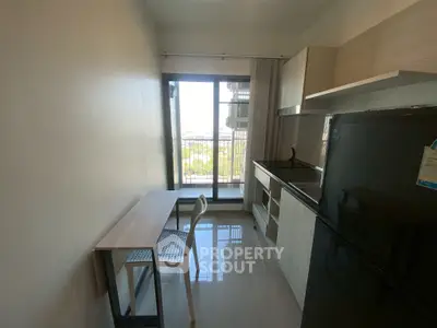 Compact kitchen with balcony view, sleek appliances, and modern design.