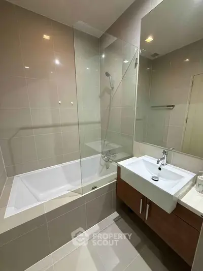 Modern bathroom with sleek design featuring a bathtub and stylish vanity unit.