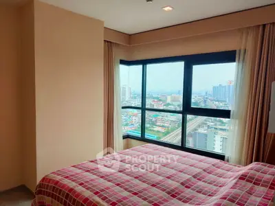 Cozy bedroom with panoramic city view from large corner windows, featuring stylish decor and natural light.