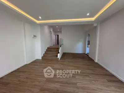Spacious modern living room with elegant recessed lighting and wooden flooring, perfect for contemporary living.