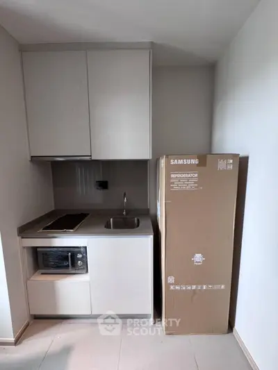 Compact kitchen with new Samsung refrigerator in modern apartment