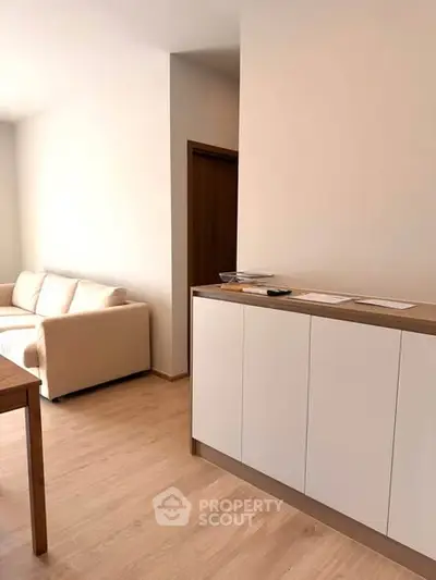 Modern living room with sleek white cabinetry and cozy beige sofa