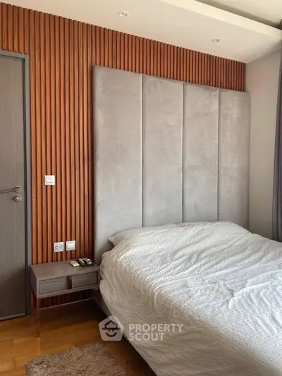 Modern bedroom with stylish wood paneling and plush headboard