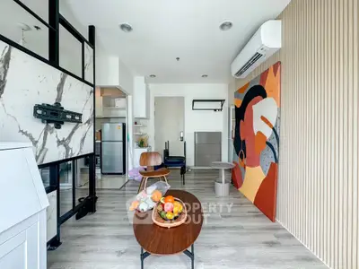Modern living room with stylish decor and open layout, featuring a vibrant wall art and sleek furniture.