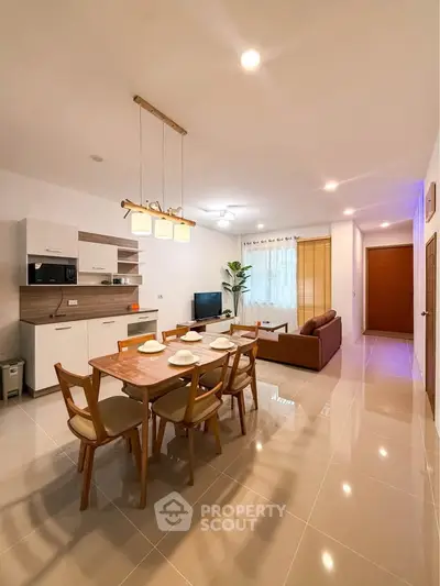 Spacious open-plan living and dining area with modern furnishings and elegant lighting.