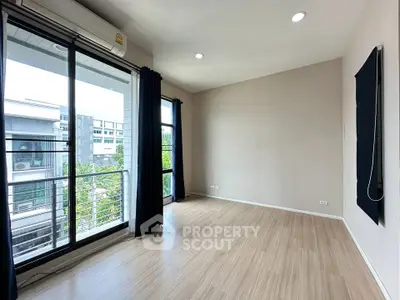 Spacious modern living room with large windows and balcony access in a contemporary apartment.