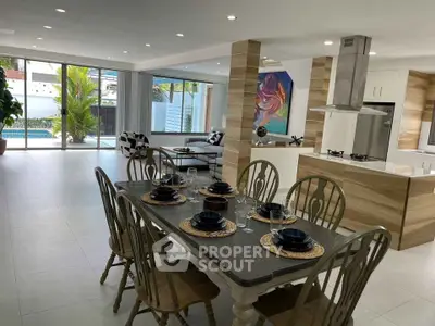 Luxurious open-plan living and dining area with modern kitchen and pool view