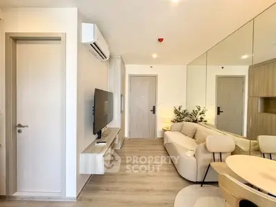 Modern living room with sleek design, featuring a wall-mounted TV, air conditioning, and stylish furniture.
