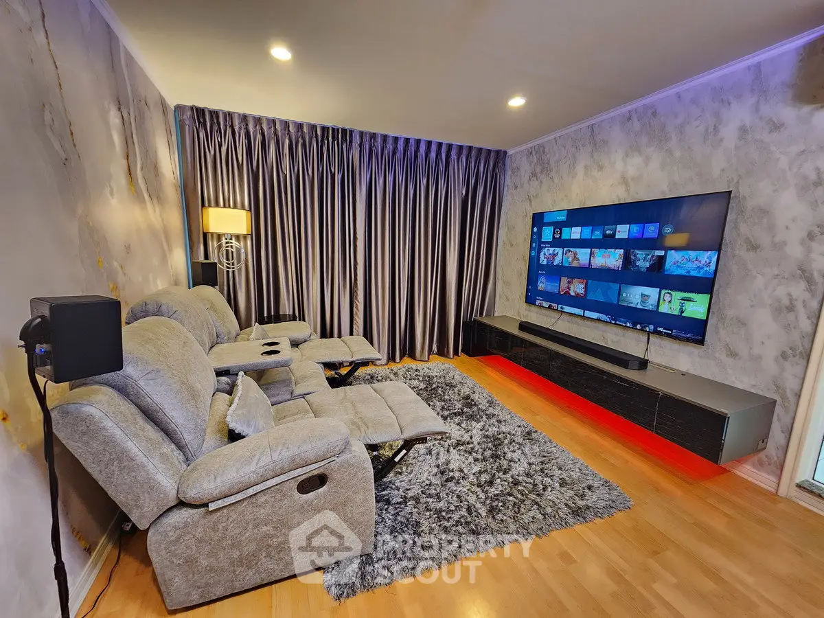 Luxurious home theater room with plush recliners and large flat-screen TV, perfect for entertainment.