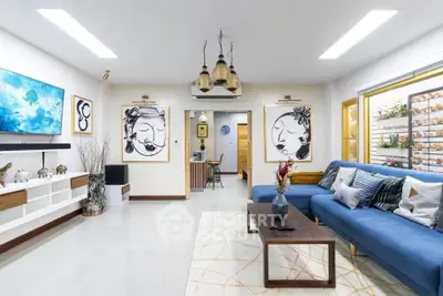 Stylish modern living room with blue sofa and artistic decor