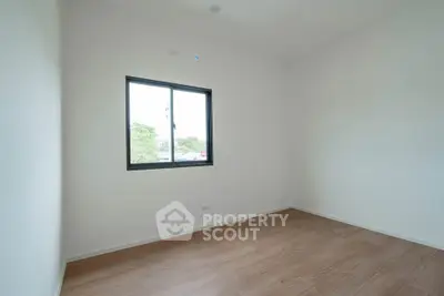 Minimalist empty room with wooden flooring and window view