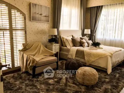 Luxurious bedroom with elegant decor, plush bedding, and cozy seating area, perfect for relaxation.