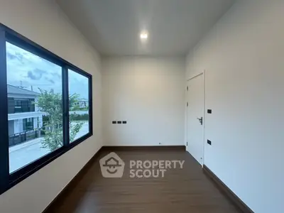 Modern empty room with large window and wooden flooring in contemporary home