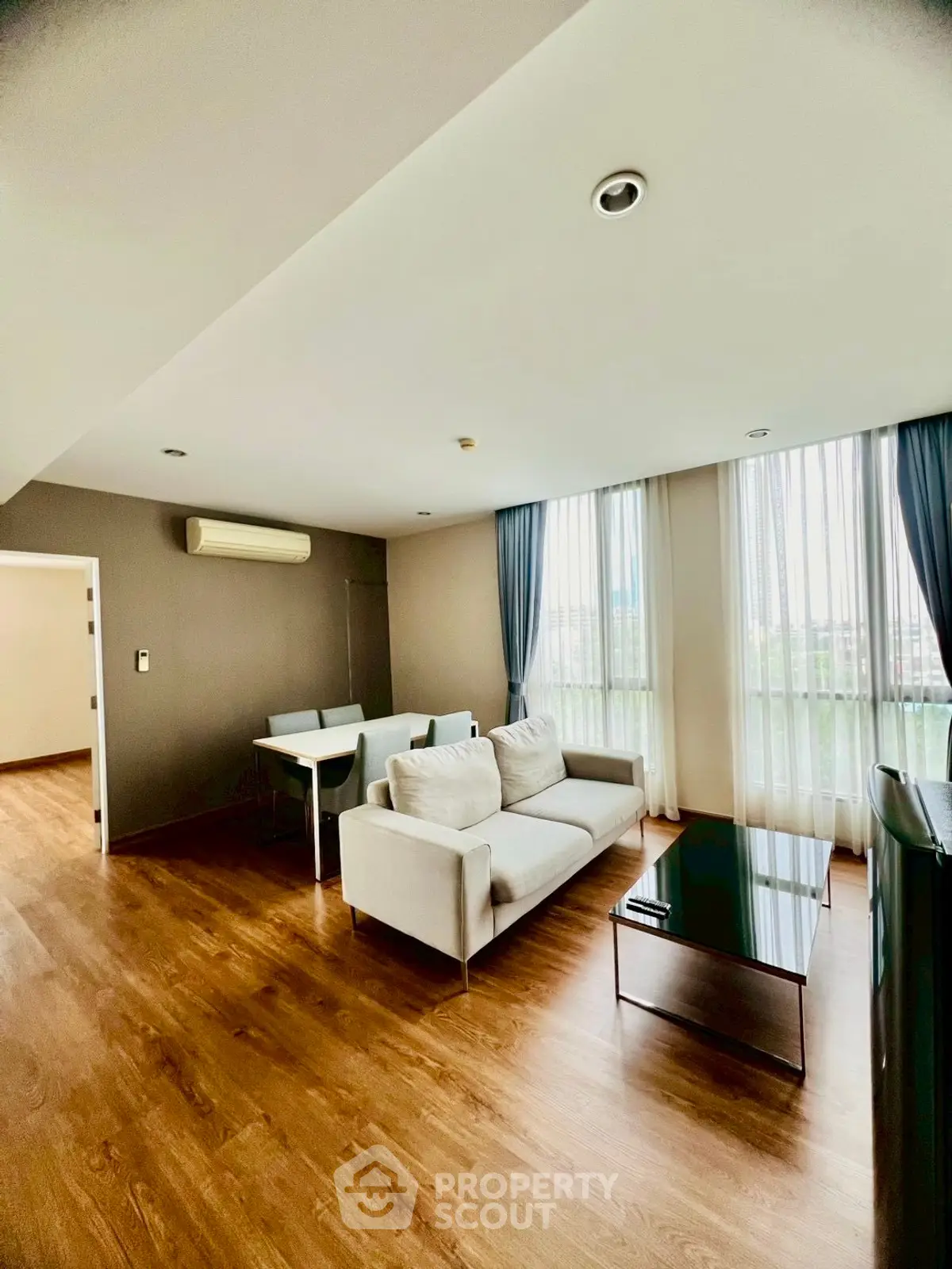 Spacious modern living room with elegant decor and large windows for natural light.