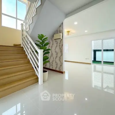 Spacious modern interior with glossy floors and elegant staircase, perfect for contemporary living.