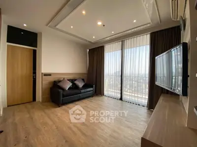 Spacious living room with modern decor and large windows offering city views.