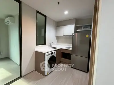 Modern kitchen with sleek appliances and open layout in stylish apartment.
