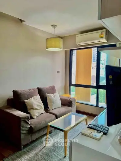 Cozy living room with modern sofa, air conditioning, and city view window in urban apartment.