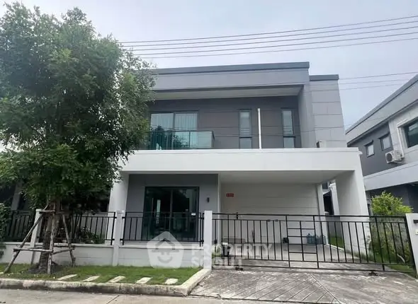 Modern two-story house with sleek design and spacious front yard.