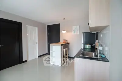 Modern kitchen with sleek cabinetry and compact dining area in a stylish apartment.