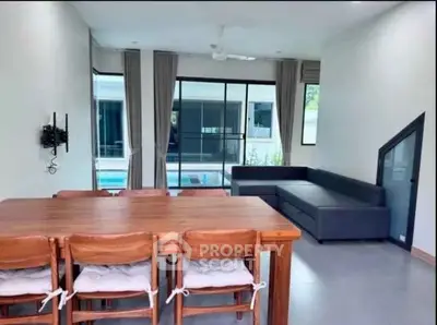 Spacious living room with pool view, featuring modern furniture and large windows for natural light.